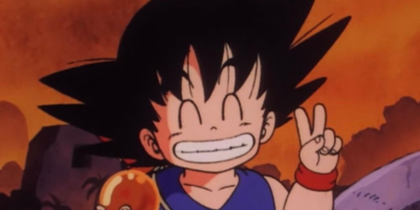 Goku holding a dragon ball smiling with a peace sign