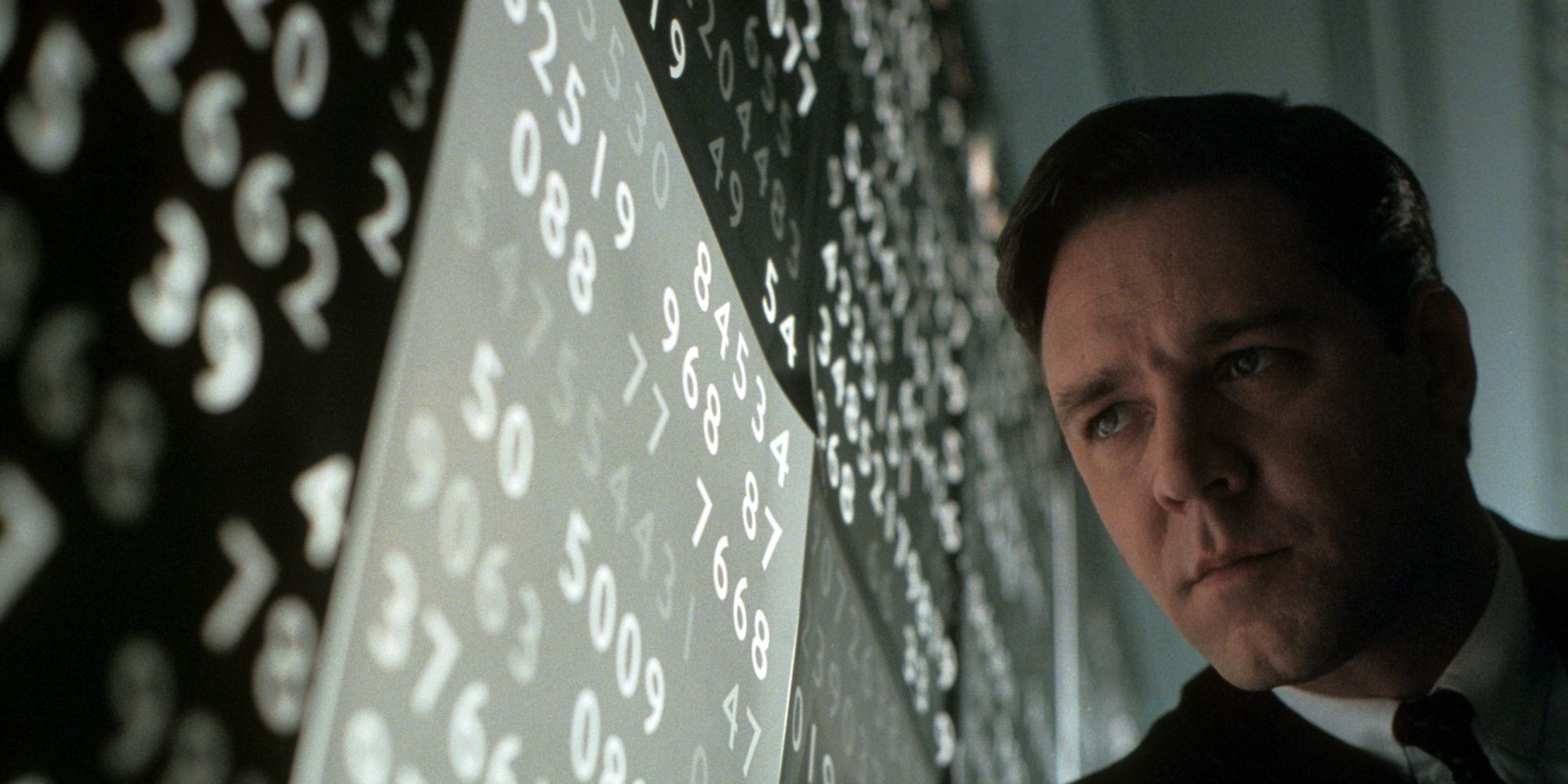 John Nash leaning against a wall of numbers in A Beautiful Mind