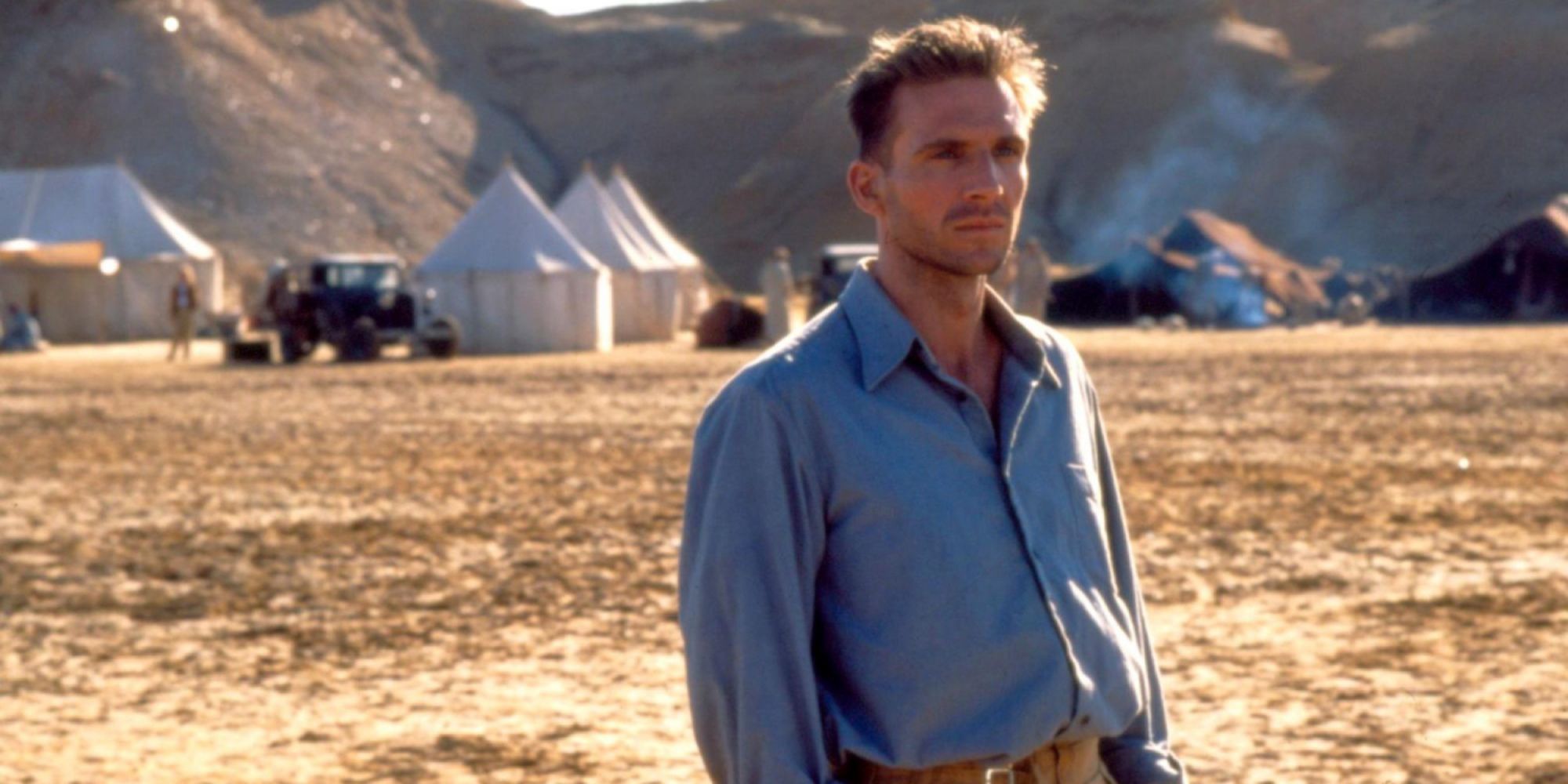 Lázló de Almasy standing in an open field looking to the distance in The English Patient