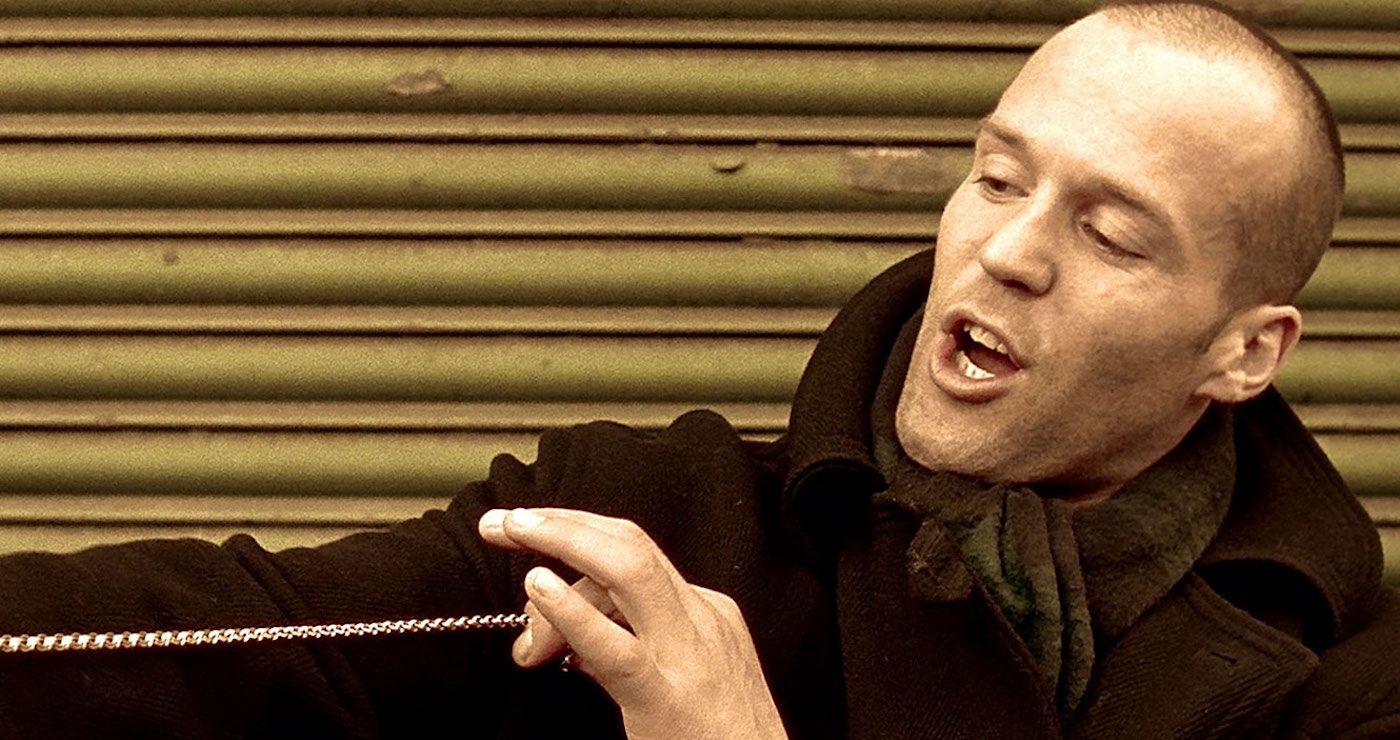 Bacon holding a chain and talking in Lock, Stock, and Two Smoking Barrels