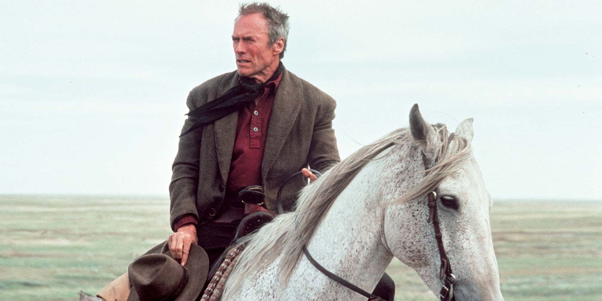 Clint Eastwood as Bill Munny riding a horse in Unforgiven