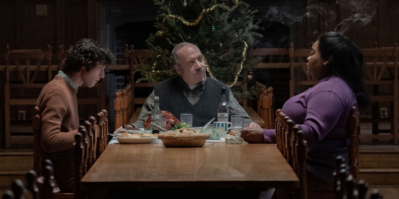 Domnic Sessa, Paul Giamatti, and Da'Vine Joy Randolph as Angus, Paul, and Mary eating in front of a Christmas tree in The Holdovers