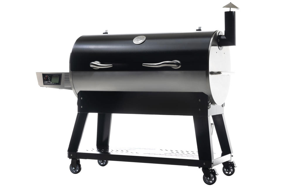Recteq Flagship XL 1400 smart pellet grill on a white background. The black and silver unit sits on a sturdy rolling cart with the company's trademark horn-shaped handles on the lid. A Wi-Fi-connected controller and display is mounted on the front of a side shelf that sits on the left side. 
