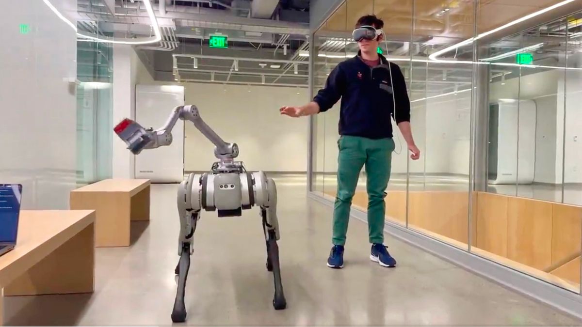 Still image capture taken from the video posted on Twitter of a man controlling a robot beside him using the Apple Vision pro headset.